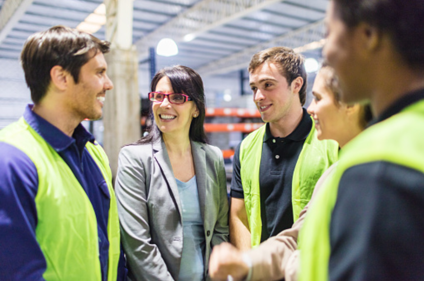 Manager talking with employees in warehouse